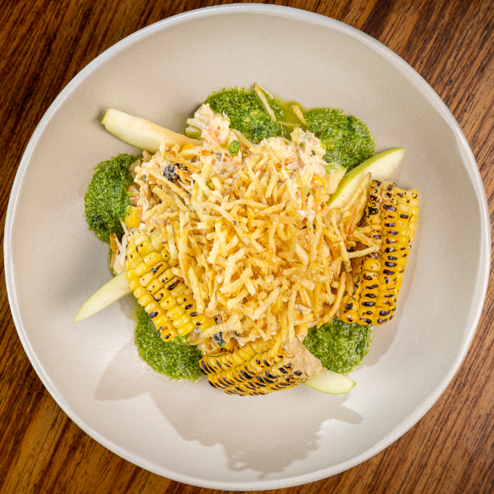 Peito de frango desfiado, maçã verde, milho, uva passa e cenoura, unidos pela maionese e finalizado com batata palha crocante, brócolis e um toque cítrico de redução de coentro.