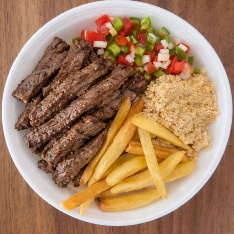 Acompanha arroz branco, feijão preto, farofa, vinagrete, batata frita e tiras de carne.