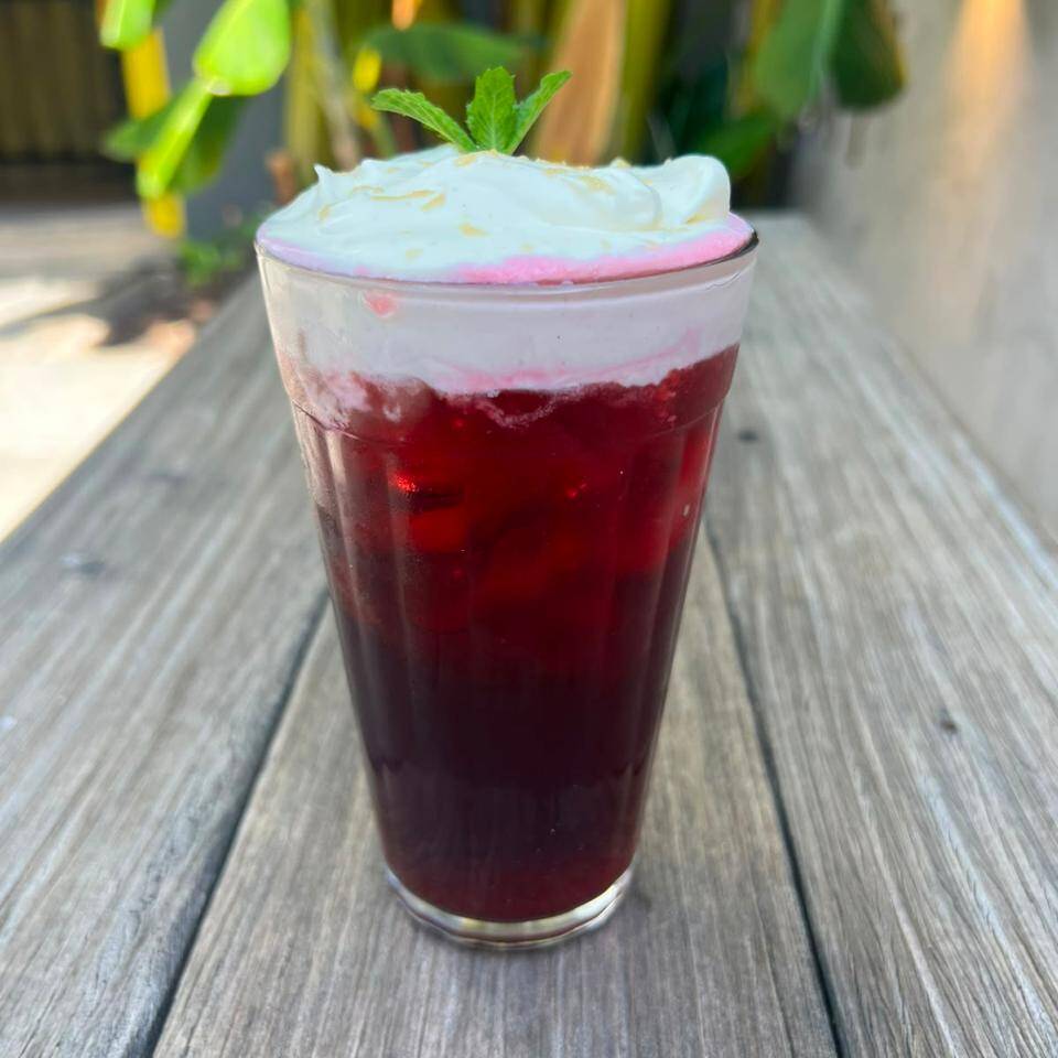 Chá de hibisco, suco natural de limão, chantilly feito por nós, raspas de rapadura e hortelã.
