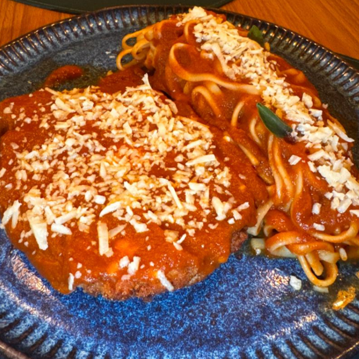 Tradicional Frango à Parmegiana, com filé de peito de frango empanado na Panko, coberto por queijo mussarela e finalizado com Molho de tomate Feito na Casa e Queijo Parmesão de Verdade. Acompanha Linguini ao Sugo.