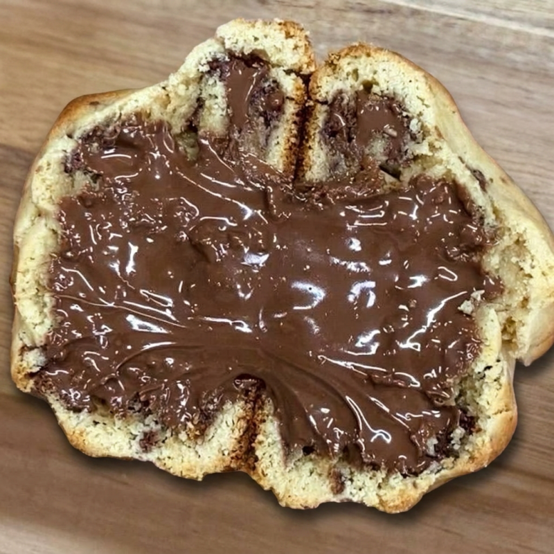 A massa é delicadamente macia e amanteigada, trazendo o sabor envolvente do leite Ninho em cada mordida. No coração do cookie, você encontrará um recheio generoso de Nutella que derrete na boca, proporcionando uma explosão de chocolate aveludado e doce que vai encantar seu paladar.