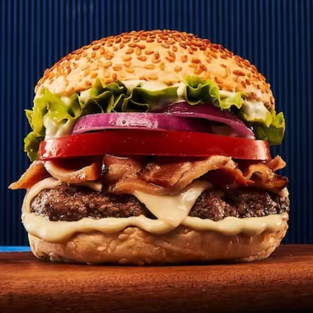 Acelere para o sabor com nosso hambúrguer de 140g, enriquecido com queijo mussarela, bacon crocante, cebola, tomate, alface e molho Supreme, tudo isso envolto por um pão de gergelim. Uma harmonia de sabores que promete uma experiência deliciosa e inesquecível.