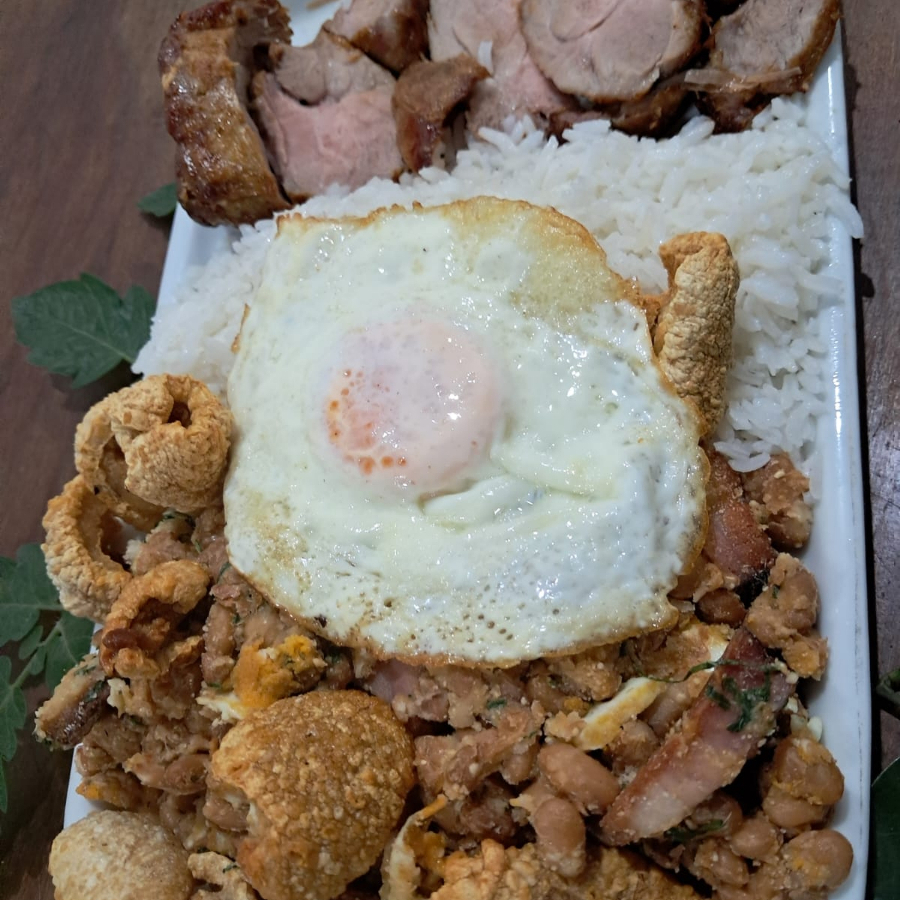 Este prato, Bife Ancho Suíno 250g + Tropeiro + Arroz é um verdadeiro deleite para os amantes de um bom churrasco. Combinamos 250g aproximadamente de Bife Ancho Suíno, que pode apresentar um belo marmoreio de gordura, garantindo um sabor suculento e inigualável. Acompanha Arroz e um autêntico Feijão Tropeiro, trazendo o sabor rústico da culinária brasileira. A carne desse prato é pesada antes de assar, garantindo a quantidade exata para sua satisfação.