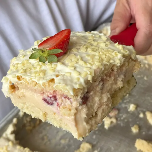 Deliciosa massa branca, incrivelmente molhadinha com calda de leite condensado, recheada com morangos frescos e brigadeiro de chocolate branco cremoso. Finalizada com nossa irresistível cobertura de creme de ninho e granulados de chocolate branco, com um toque especial de morango no topo. Uma explosão de sabores que vai te surpreender!