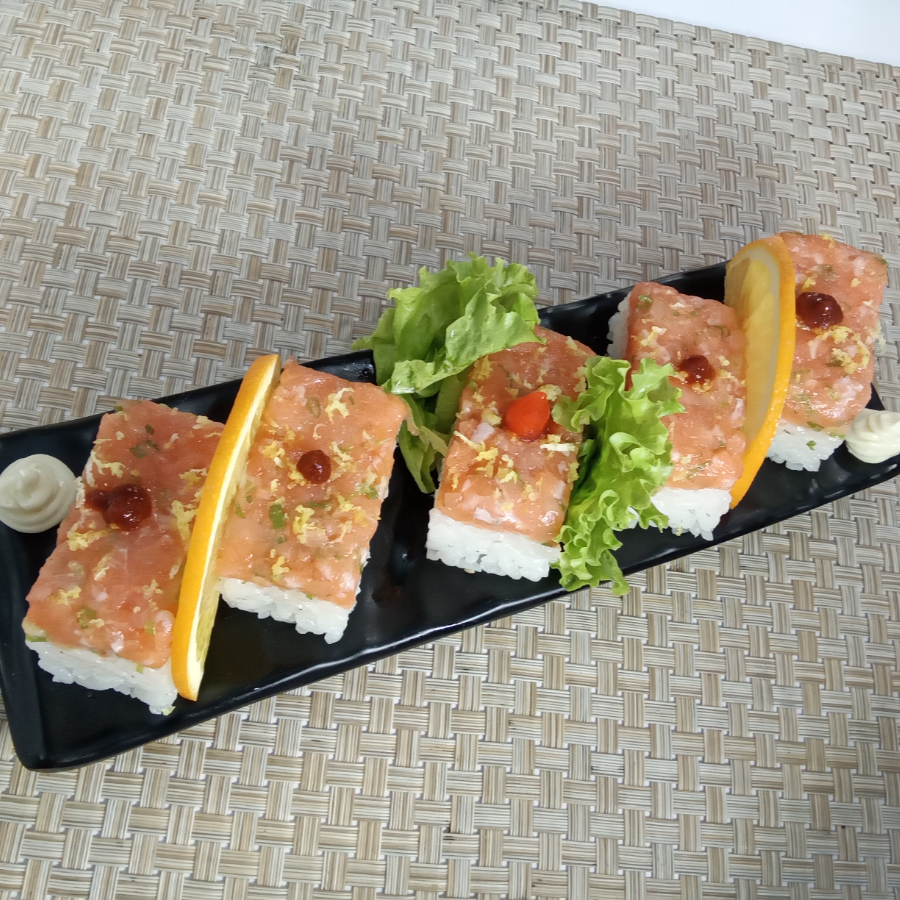 Base de arroz, cobertura de salmão com cebolinha, finalizado com raspa de limão, flor de sal e um leve toque de pimenta