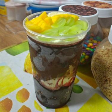 Manuella Açaí - 8 Adicionais Grátis. Um festival de sabores e qualidade incomparável! Este açaí de 770ml é uma combinação irresistível e harmoniosa de paçoca, amendoim, disquetes, jujubas, granulado colorido, leite em pó, granola, aveia, flocos de arroz, cereal chocoball, leite condensado, que se unem às frutas frescas como morango, banana, uva e manga. Cada ingrediente é selecionado com rigor, garantindo a melhor qualidade em cada colherada. Acreditamos que o amor transparece na comida, por isso, preparamos tudo com o mais profundo carinho, sem comprometer o seu orçamento. Temos a certeza de que você vai se apaixonar a cada degustação! ️
