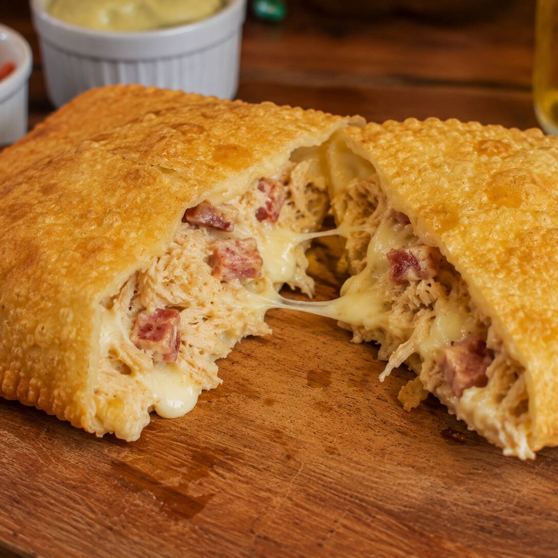 Frango desfiado e bem temperado, bacon douradinho e Catupiry cremoso, formando uma combinação irresistível de sabores e texturas. Um recheio generoso, cremoso e cheio de sabor, envolvido em uma massa sequinha, crocante e douradinha. 🤤