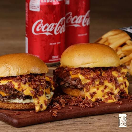 Combo Bacon Cheddar em Dobro! hambúrgueres artesanais de 120g, com queijo cheddar cremoso, fatias crocantes de bacon, alface americana fresquinha e tomate no pão macio. Uma explosão de sabor em dose dupla pra matar sua fome com estilo!