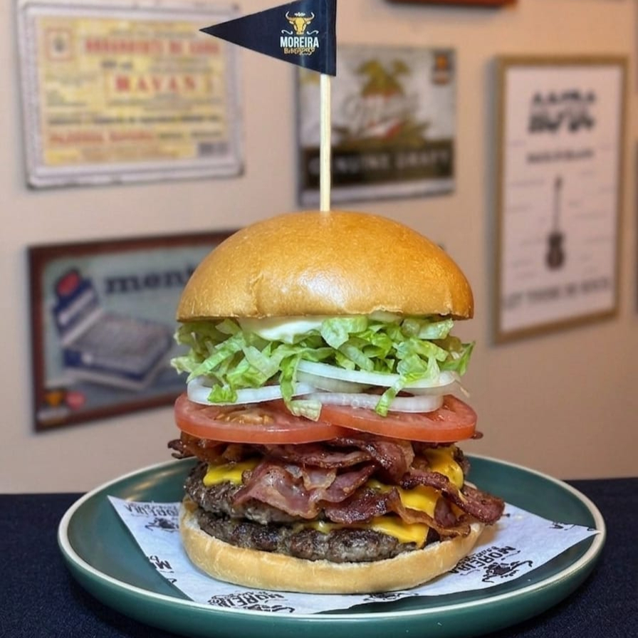 Dois Belos Suculento Burger Angus, Fatias de Queijo Cheddar Americano, Alface Americana Picado, Fatias de Bacon Crocante, Cebola Crua, Tomate, Ketchup, Maionese. Servido no Pão Levemente Selado