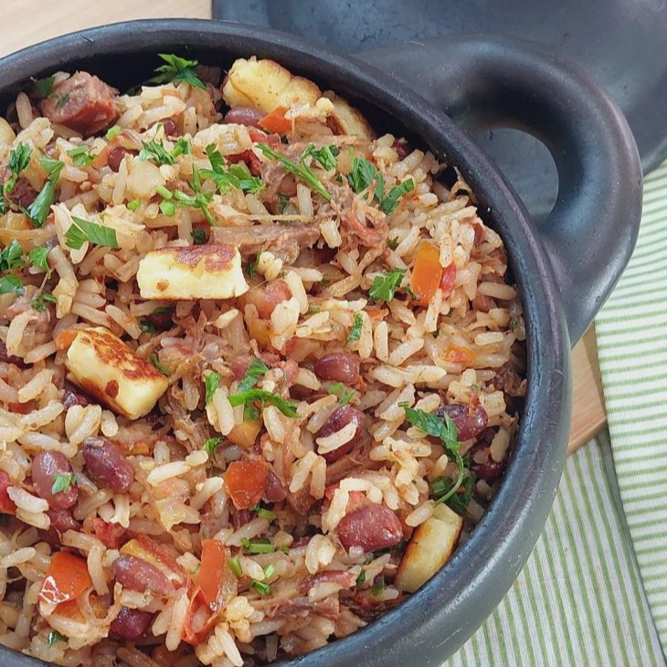 A 'Marmita de Baião de Dois500g', uma das nossas opções mais vendidas, é um prato recheado de sabor e tradição. Começa com um arroz branco soltinho, perfeitamente cozido. Acrescentamos uma generosa porção de pernil desfiado, cubos de calabresa defumada e pedaços suculentos de bacon. O feijão fradinho é misturado com queijo coalho derretido, criando uma combinação irresistível. Para finalizar, adic