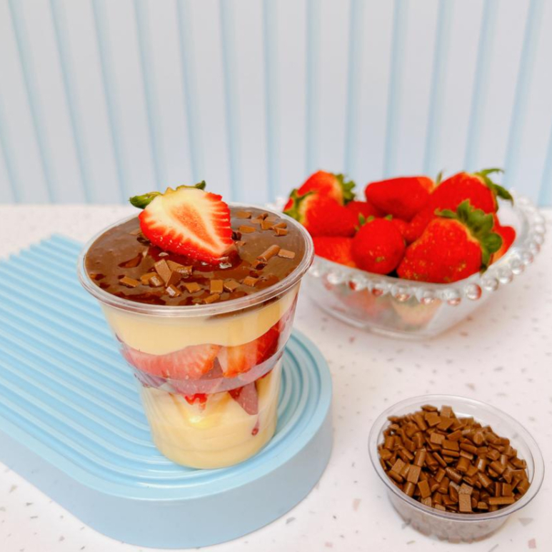 Delicioso brigadeiro cremoso de Ninho com morangos frescos finalizado com uma ganache meio amargo.