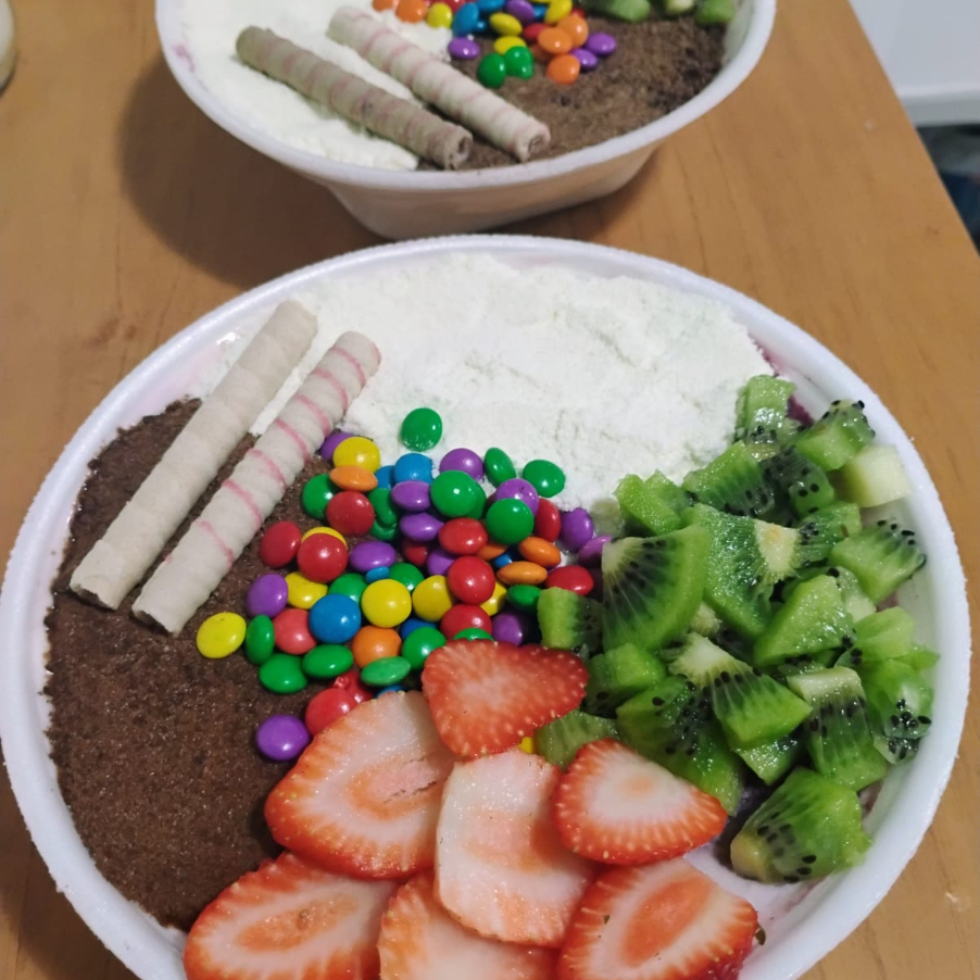 Dois ícones da Amazônia em uma só tigela. O Açaí & Cupuaçu Tropical 500ml une cremosidade, sabor autêntico e personalização completa — 100% natural, zero lactose e sem glúten. Como funciona Escolha até 2 sabores: Açaí Premium: Tradicional, Banana, Morango ou Leitinho (chocolate branco). Cupuaçu Premium: tropical, levemente azedinho e super cremoso. Ganhe grátis: 3 acompanhamentos à escolha. 1 calda premium: chocolate, morango ou caramelo. 1 fruta fresca: banana ou morango. Por que amar Rico em antioxidantes e energia natural. Textura cremosa e sabor equilibrado (doce do açaí + refrescância do cupuaçu). Combo versátil para qualquer hora do dia. Sugestões de combinações Clássico da Amazônia: Açaí Tradicional + Cupuaçu + granola + calda de chocolate. Tropical Fresh: Açaí Banana + Cupuaçu + Leite Ninho + calda de morango. Choco Lovers: Açaí Leitinho + Cupuaçu + M&M’s + calda de caramelo. Peça agora e prove a dupla perfeita da Amazônia em 500ml!