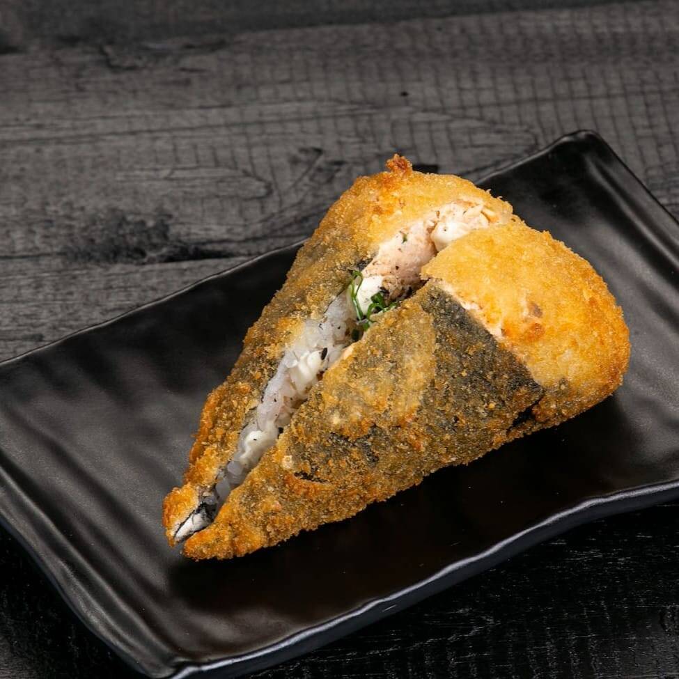 Salmão grelhado batido com cream cheese e couve frita, empanado na farinha e frito.
