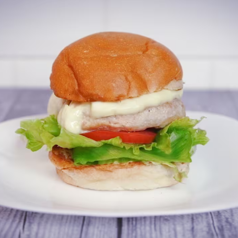 Hambúrguer de frango, alface, tomate, queijo minas e molho da casa.