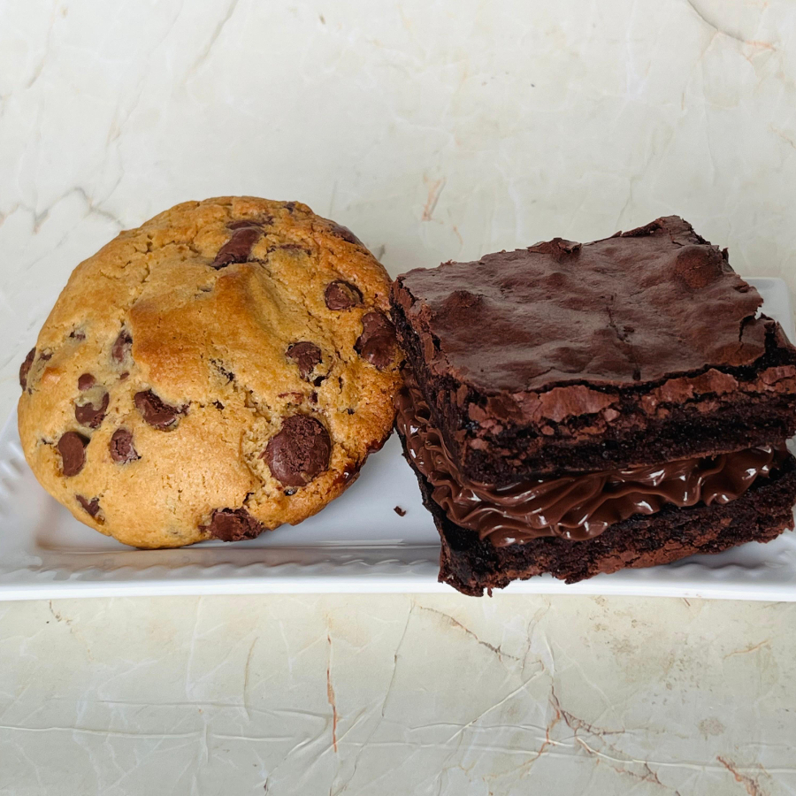 Cookie artesanal levemente crocante por fora, macio por dentro preparados com açucar mascavo e açucar demerara, recheado com brigadeiro. Acompanha brownie grande, denso e chocolatudo super recheado — cremoso de verdade. Feito. aprox 250gm (total)