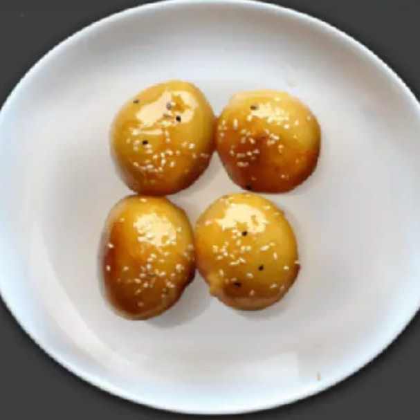 maça empanada frita e caramelizada salpicada com gergelim.