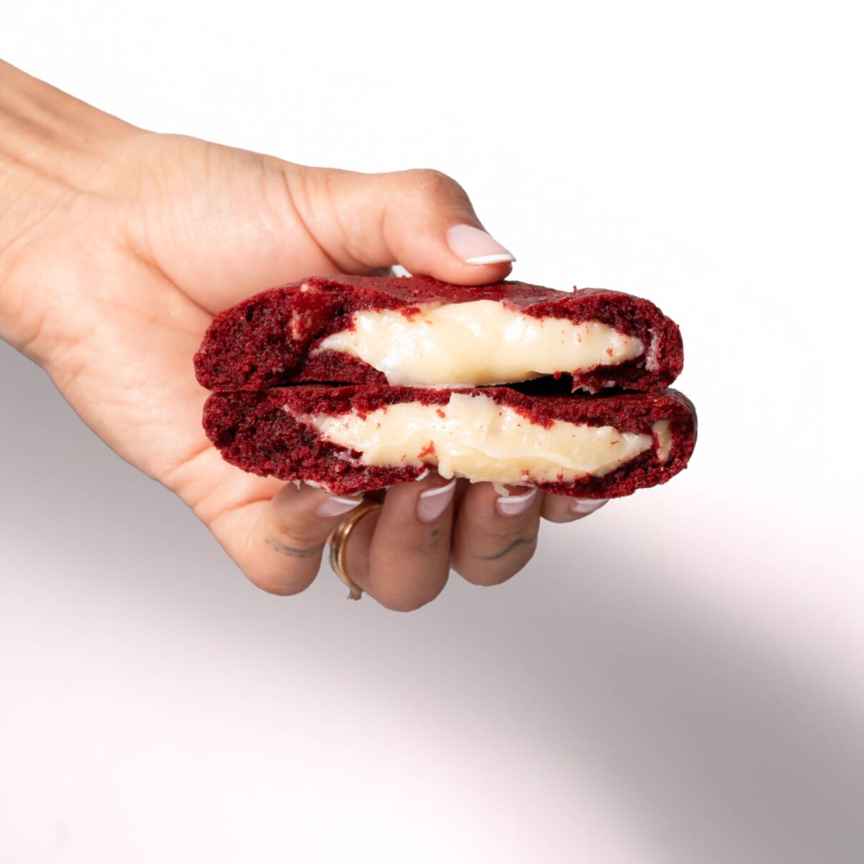 Cookie vermelho de cacau com pedaços de chocolate branco e ultra recheio de brigadeiro gourmet de Leite Ninho.