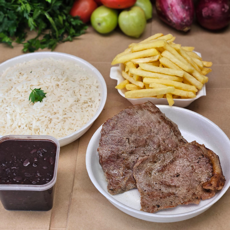 Sabe aquela comida caseira, preparada com temperos naturais e muito capricho? É exatamente isso que oferecemos em nossos kits: refeições feitas com amor, do jeito que servimos em nossas próprias casas. Nesse kit, você receberá o seu pedido da seguinte maneira: - Arroz temperado com cebola e alho (350 g) – Marmita P - Feijão do Dia (250 ml) – Potinho lacrado - Batata frita crocante (120 g) – Marmitinha H3 - bife de coxão mole grelhado (160 g) – Marmita M Serve 1 a 2 pessoas