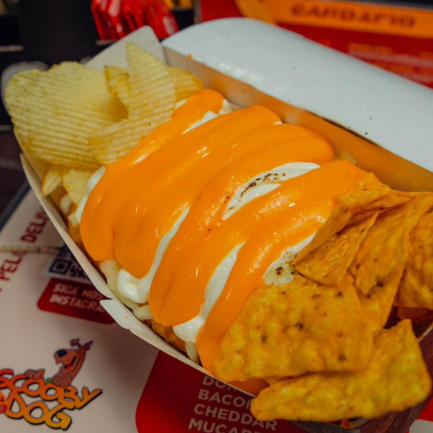 Pão Brioche, Molho de Tomate, 3 salsichas, Bacon, Batata Palha, Milho, Doritos, Cream Cheese, Muçarela, Cheddar, Ketchup, Maionese, Mostarda (Acompanha Batata Chips)