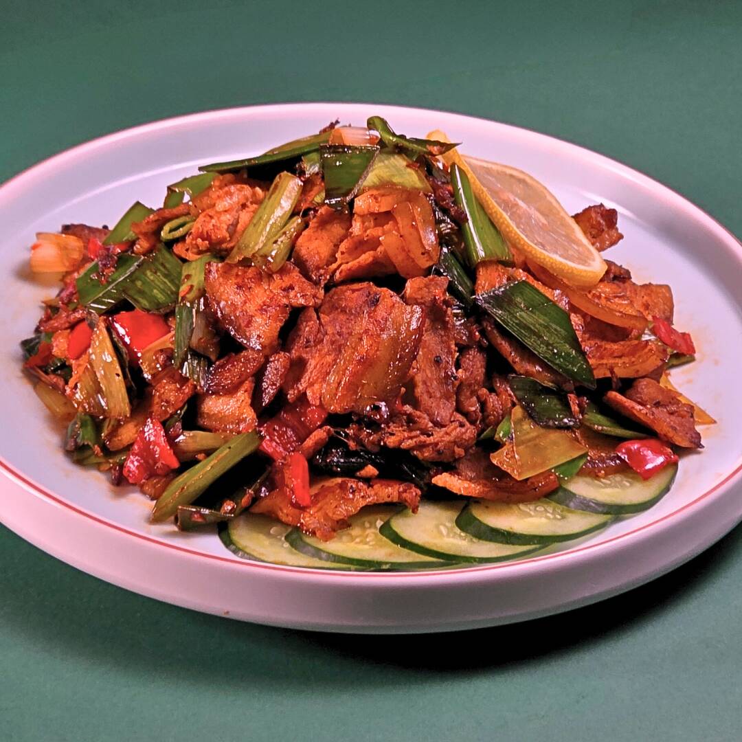 Pancetta glaceada no wok com pimenta fresca e alho-poró.