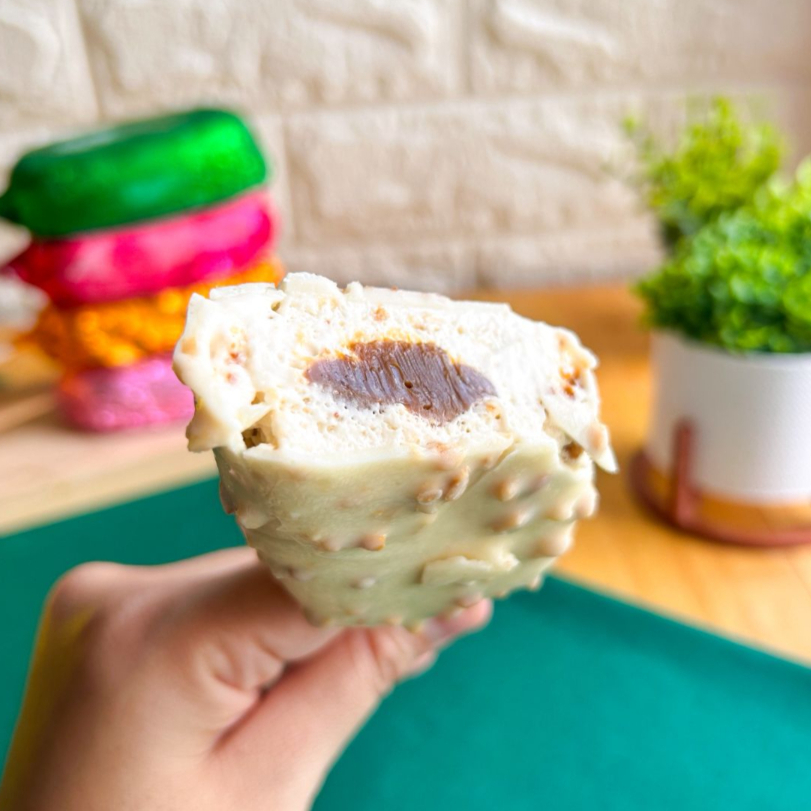 Base cremosa de paçoca com delicioso recheio de doce de leite e casquinha de chocolate branco com amendoim. O sabor clássico brasileiro em versão gourmet.