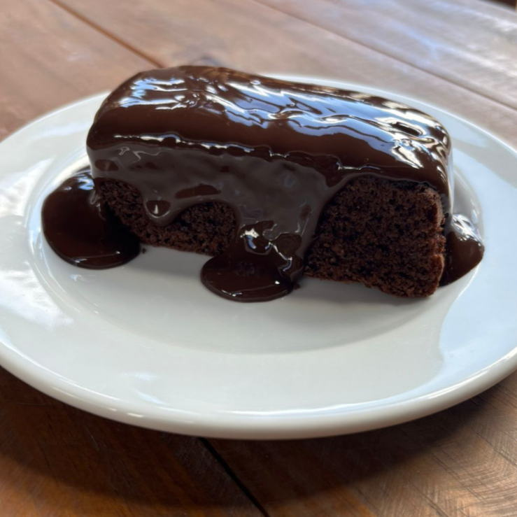 Bolo de chocolate fofinho e saboroso, coberto com brigadeiro cremoso que deixa cada pedaço ainda mais irresistível. Doce caseiro do Aruá que combina com qualquer momento.