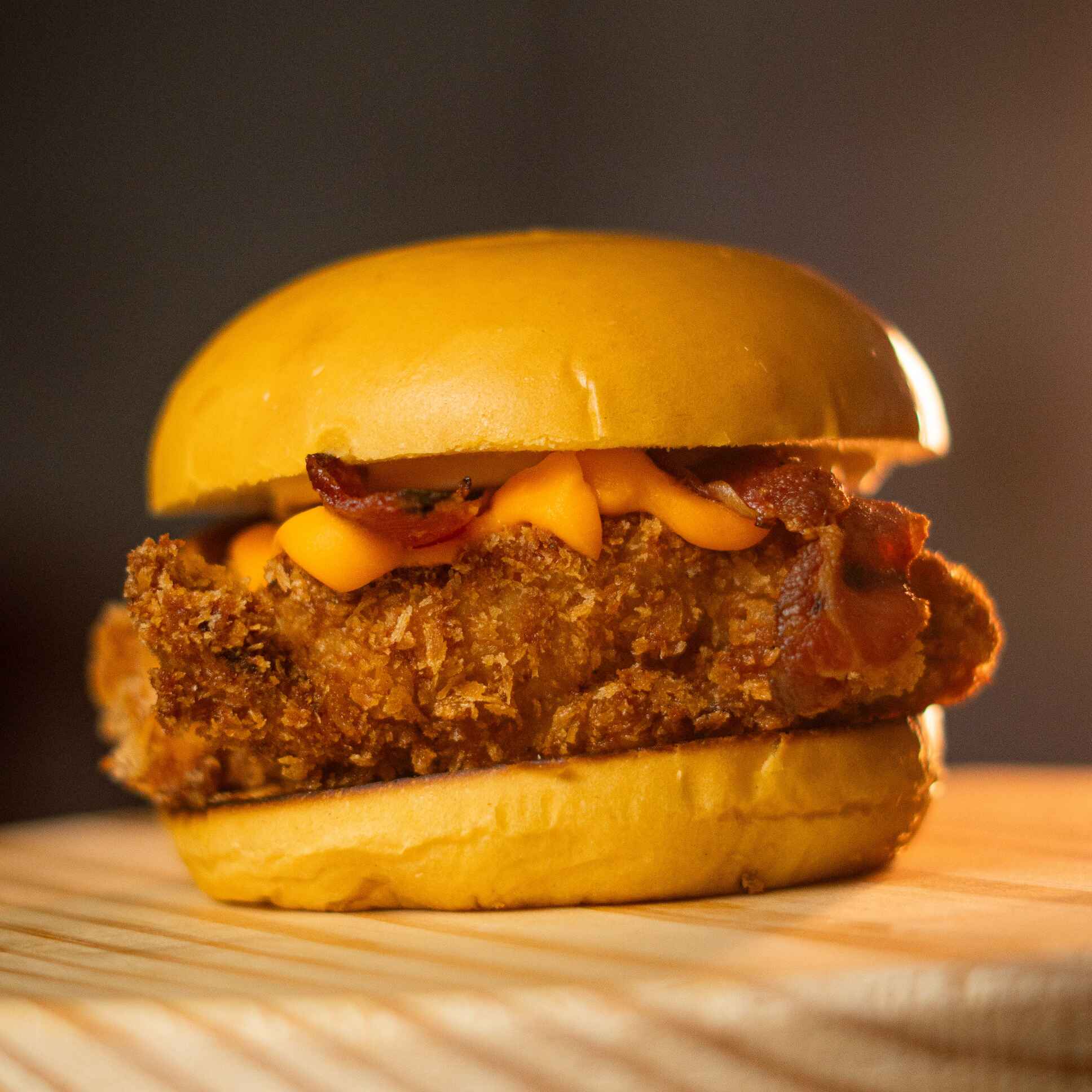 Pão brioche , maionese Grill , Tiras de Filé de Frango empanado e Frito , Cheddar Cremoso e Bacon Fatidos.