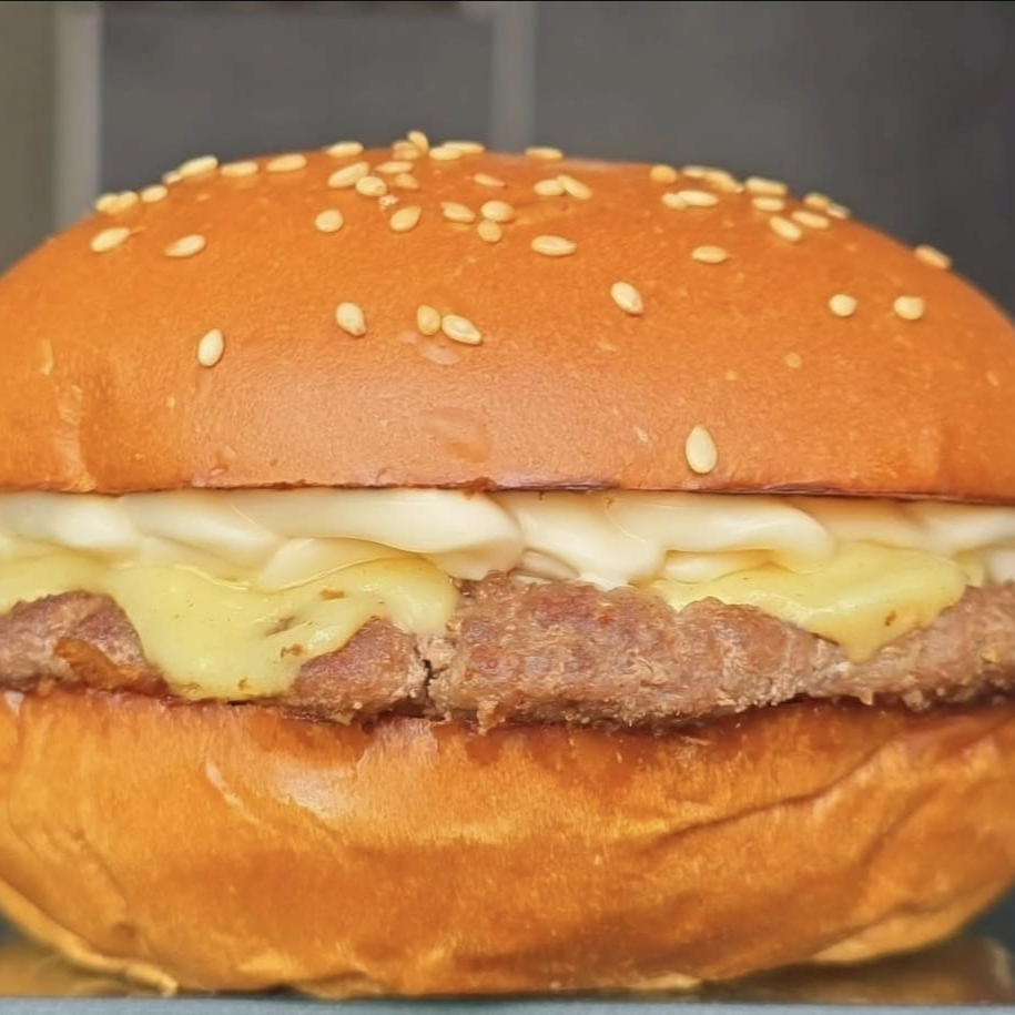 Burger Fininho de 100g (Fake Smash) feito no charbroiler, 2 fatias de queijo prato top, molho the best suculento em um pão brioche artesanal com gergelim bem fofinho. Obs.: não alteramos o queijo e nem o ponto da carne.