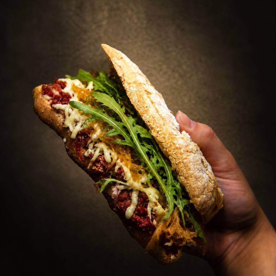 Lanche Artesanal feito com: Pão ciabatta artesanal, crocante por fora e macio por dentro, recheado com carne seca desfiada, cebola caramelizada e rúcula fresca. Combinação marcante, com sabor intenso e equilibrado.