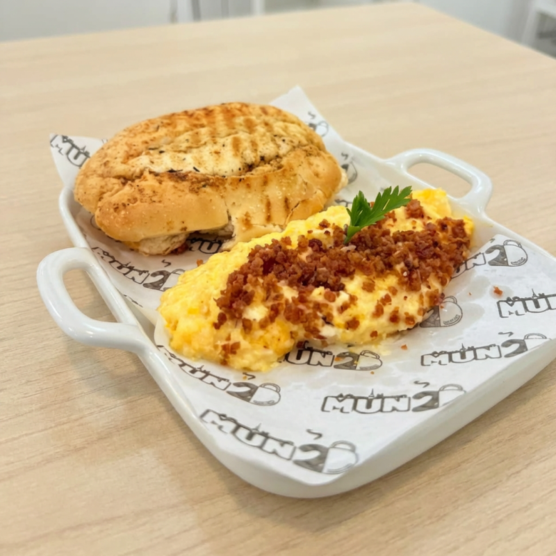 Pão Brasileiro tostado, acompanhado de ovos mexido com Cream cheese e farofa de bacon.