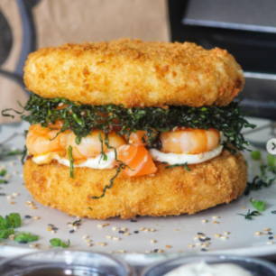 Delicioso arroz temperado empanado cortado ao meio, pedaços de salmão e camarão, couve crispy, cebola roxa fatiada, cream cheese e cebolinha pra finalizar.