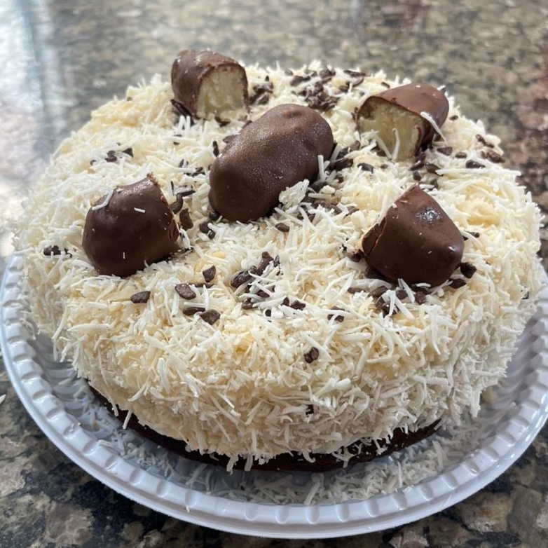 Massa de chocolate, recheada com creme de coco cremoso, finalizado com granulado de chocolate e um bombom de coco.