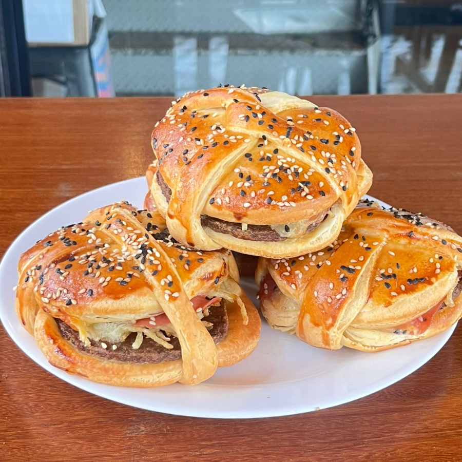 Sanduíche assado com hambúrguer suculento, queijo derretido, presunto e crocância da batata palha