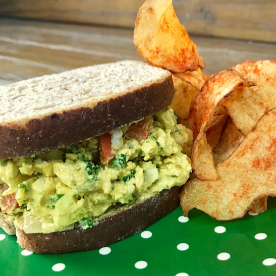 Sanduíche frio: tofu no açafrão com cebolas douradas, cenoura salteada, tomate-cereja assado, azeitonas e ervas frescas no pão-de-forma integral. Atenção: não é possível alterar o prato. Contém glúten. Chips de batata não inclusos.