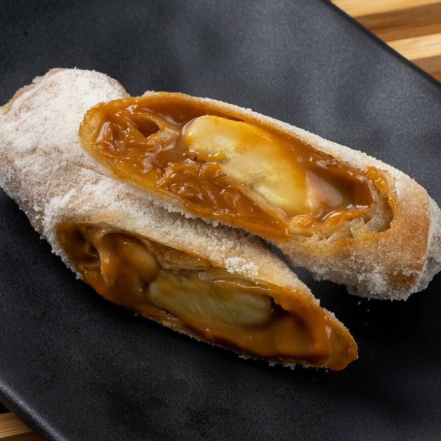 Massa crocante de harumaki polvilhada com açúcar e recheio de banana com doce de leite.