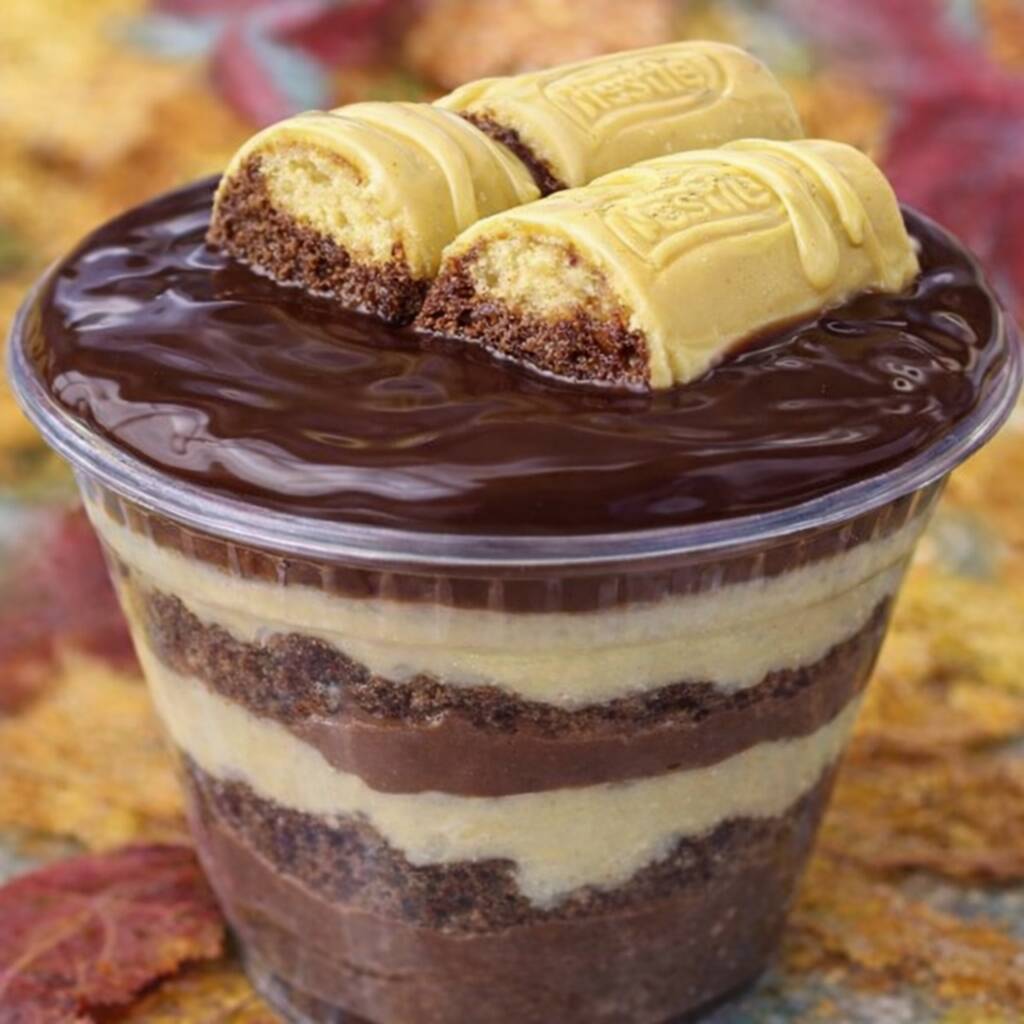 Copo da Felicidade com camadas generosas de creme branco super cremoso e mousse de chocolate intenso, intercaladas com brownie macio e úmido. Finalizado com uma camada lisa e brilhante de ganache de chocolate por cima e pedaços de chocolate branco que deixam cada colherada ainda mais especial.