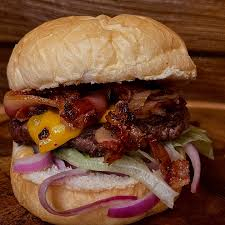 Pão de burguer, blend bovino 150g, queijo prato, costela pulled pork, sour cream e picles de cebola roxa.