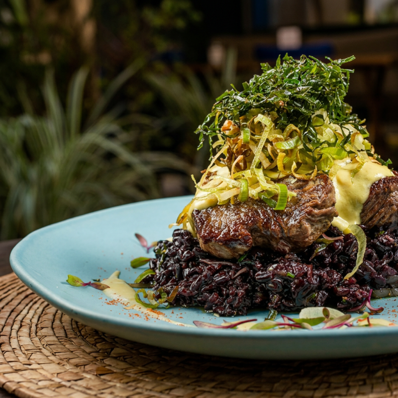Filé mignon bovino (160g in natura) servido com arroz negro ao molho de mostarda dijon e crispy de alho poró