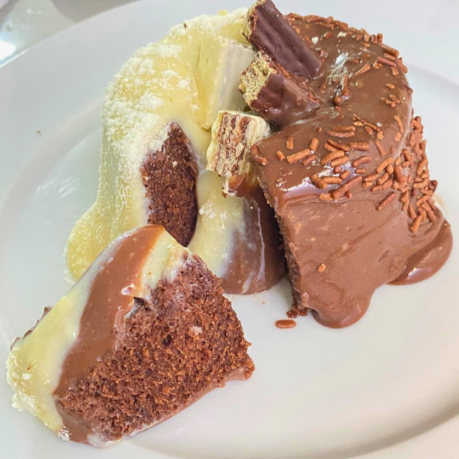 Mini bolo vulcão feito com massa de chocolate fofinha, recheio generoso de creme de Ninho e cobertura de chocolate cremoso, com efeito vulcão irresistível. Uma combinação equilibrada entre o doce do Ninho e a intensidade do chocolate. Produção artesanal, enviado em embalagem individual tipo hamburgueira, ideal para presente ou sobremesa.