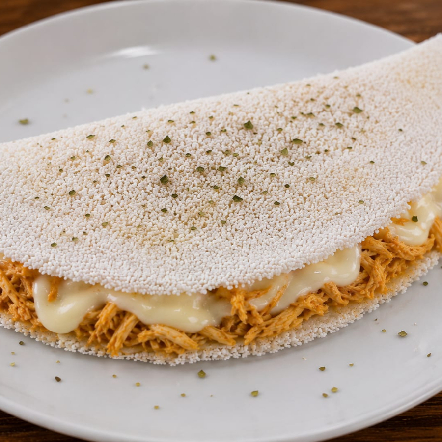 Uma combinação clássica e apaixonante! Tapioca macia e preparada na hora, recheada com frango desfiado bem temperado e catupiry supercremoso, proporcionando uma explosão de sabor e cremosidade a cada mordida. Perfeita para quem ama recheios generosos e irresistíveis!