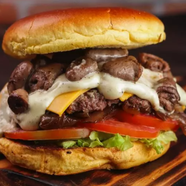 Pão bola, deliciosa carne artesanal tostada na chapa, 1x porção de coração assado na chapa, queijo cheddar derretido em cima da carne, alface fresquinho do Dia , tomate salada, cebola caramelizada ao shoyo, e por fim 1x camada de maionese cremosa artesanal.