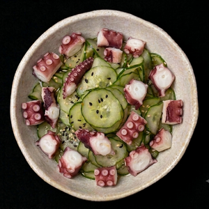 Salada de pepino marinada com polvo finalizada com gergelim.