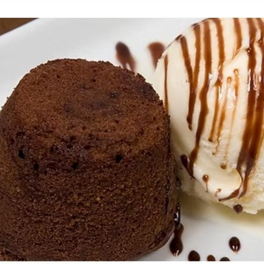 Bolo de chocolate com calda de chocolate quente, servido com sorvete de creme.(INGREDIENTES Ovo integral pasteurizado, chocolate meio amargo, manteiga sem sal, açúcar refinado, farinha de trigo, gema de ovo pasteurizada e sal refinado. Contém glúten. )