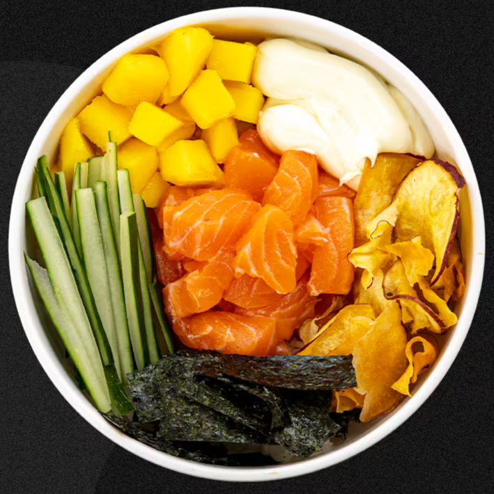 Base de arroz japonês, salmão fresco em cubos, cubos de manga, pepino fatiado, cream cheese, tiras de alga nori e chips de batata doce.