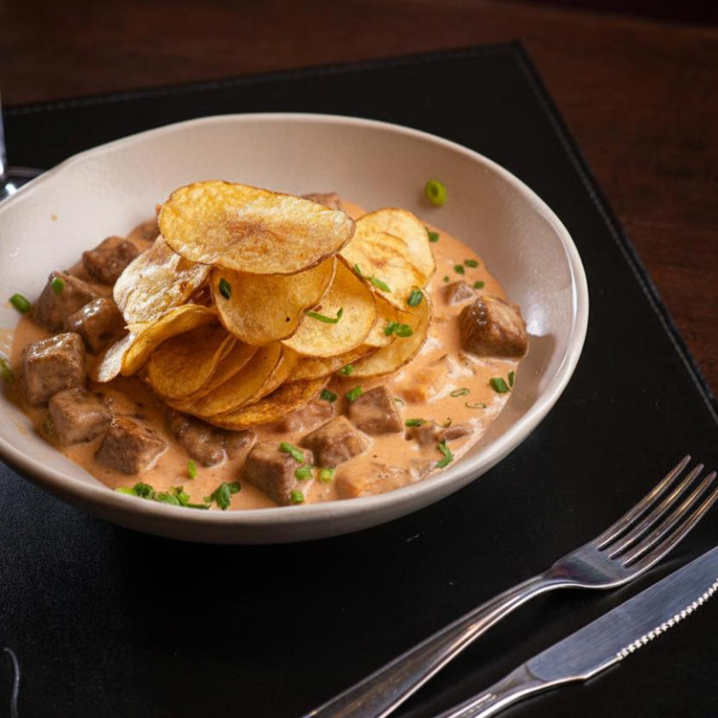 Strogonoff de carne cremoso, acompanhado de arroz e batata, com uma lata de Guaraná Antarctica de cortesia. Conforto e sabor em uma refeição completa!