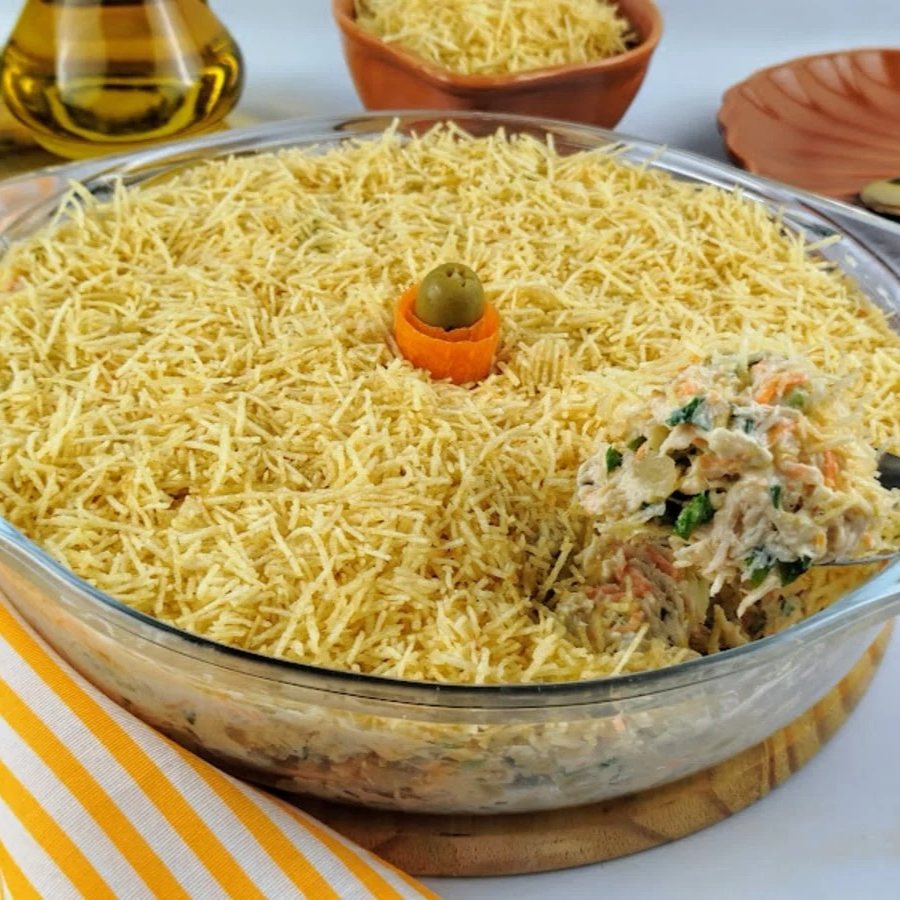 Delicioso preparado com peito de frango desfiado com cenoura, azeitonas, presunto, milho, passas e batata palha.
