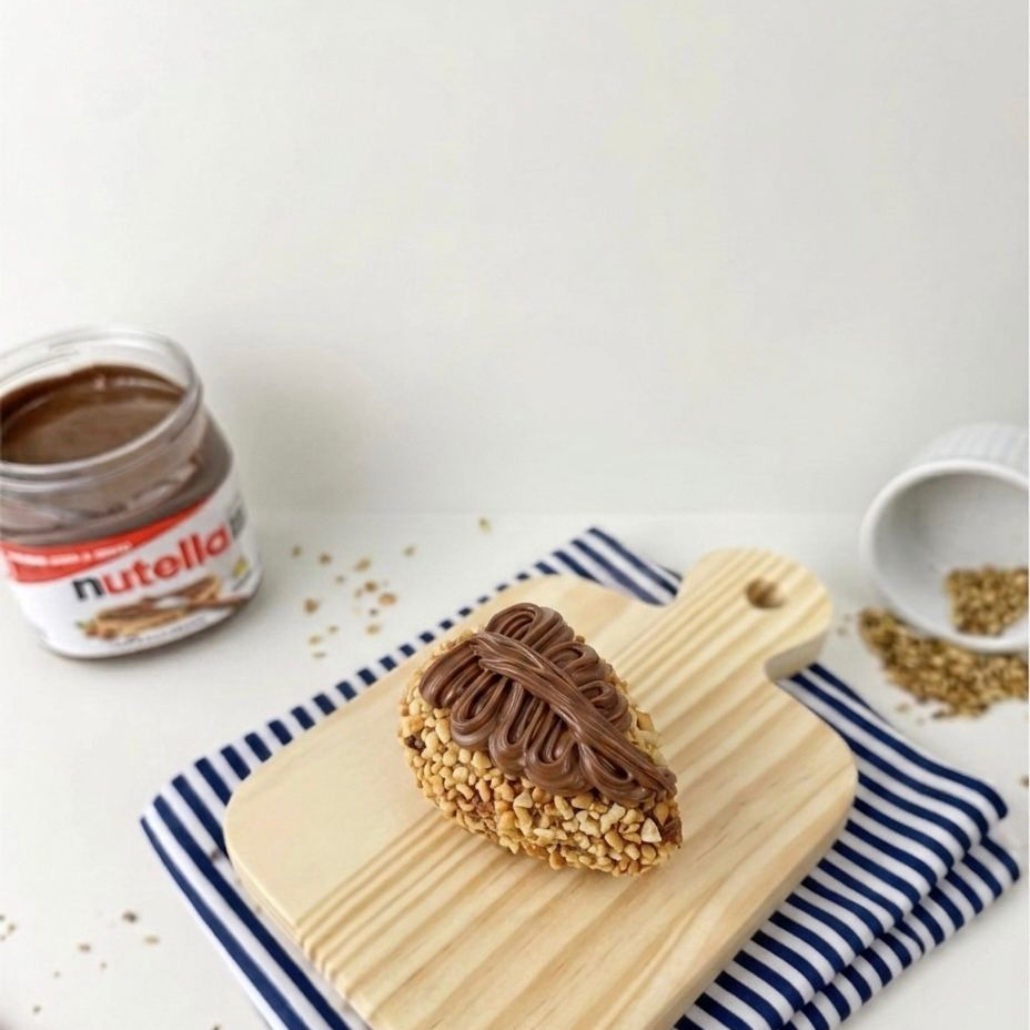 Brigadeiro 50% cacau cremoso, crocantes de avelã, cobertura de Nutella e um morango fresco e suculento no recheio. Simplesmente irresistível!