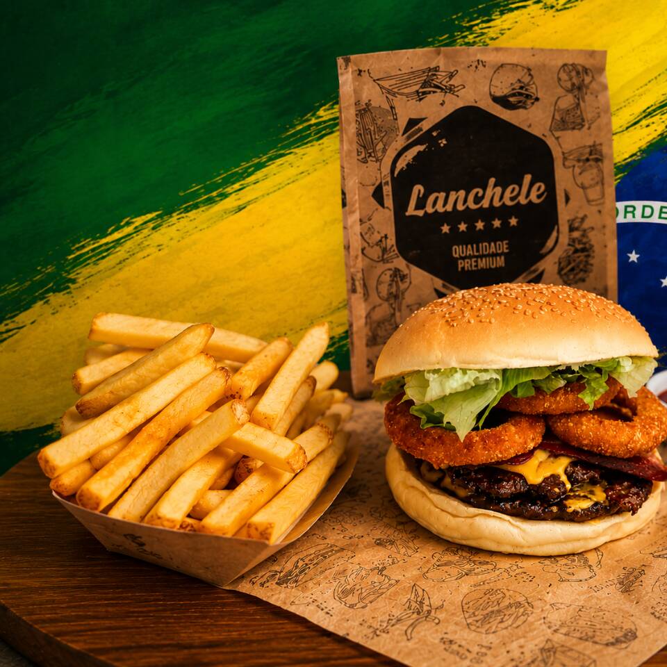 Um hambúrguer irresistível preparado no pão macio com gergelim, carne bovina suculenta, cheddar derretido, bacon crocante, anéis de cebola empanados e alface fresca. Acompanha uma generosa porção de batatas fritas douradas e crocantes, servidas com molho especial para uma experiência completa de sabor.