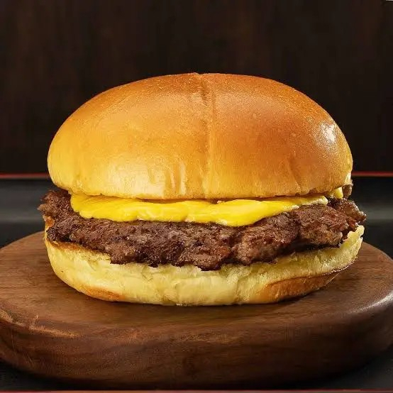 Delicioso hambúrguer com queijo cheddar em um pão de brioche e maionese