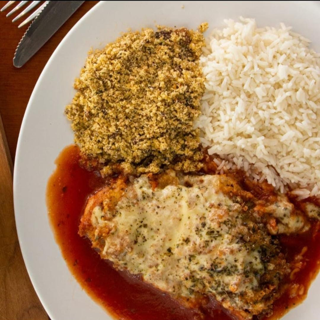 Bife de frango parmegiana acompanhado de arroz branco, feijão vermelho e farofa crocante